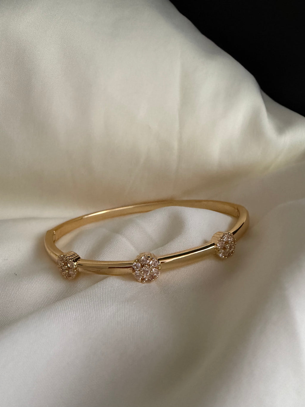 Gold plated bangle with rhinestone flowers