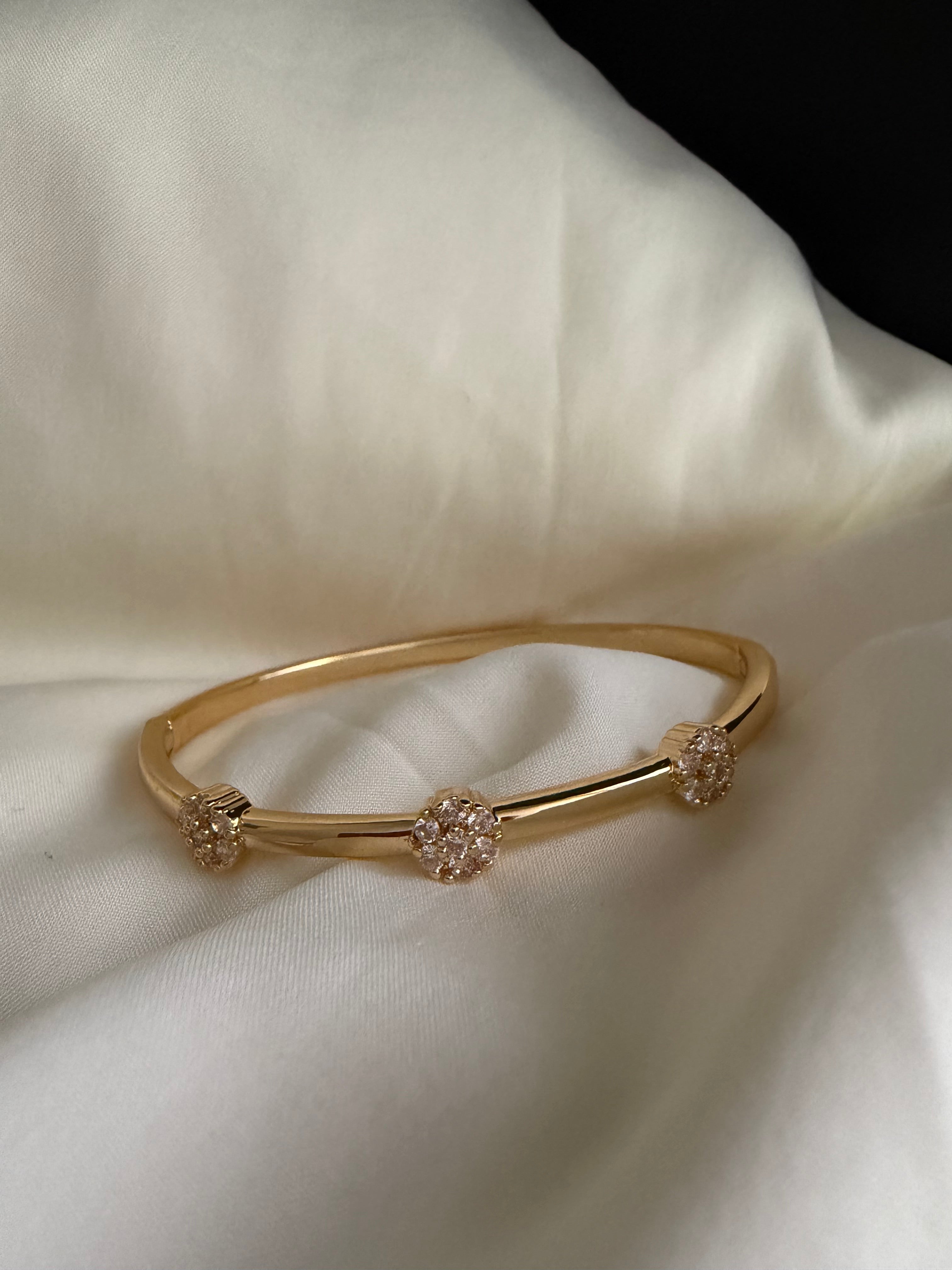 Gold plated bangle with rhinestone flowers